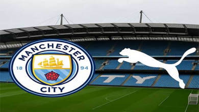 Vue de l’Etihad Stadium avec le logo de Manchester City et le logo de Puma affichés au premier plan